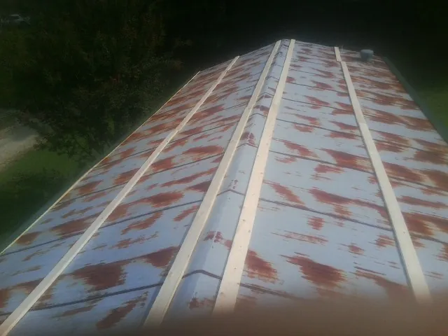 Rusted metal roof panels with new wood purlins before replacement — Storm Damage Roof Repair in Tully by Roofing Brothers