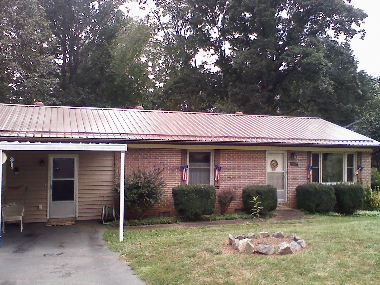 Bronze metal roof and carport on a brick ranch home — Roof Repair work by our crew in Tully
